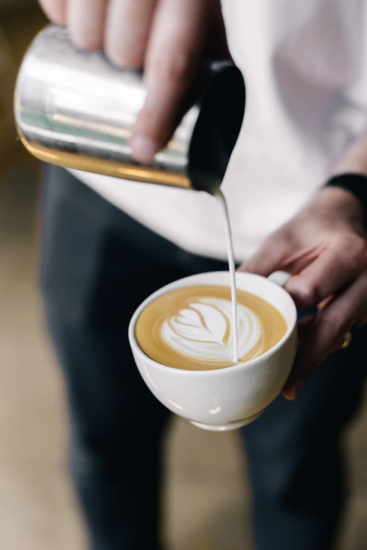 someone pouring cream into a cup with a spoon