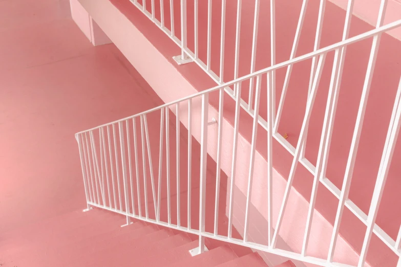 a stair railing with pink flooring against a wall