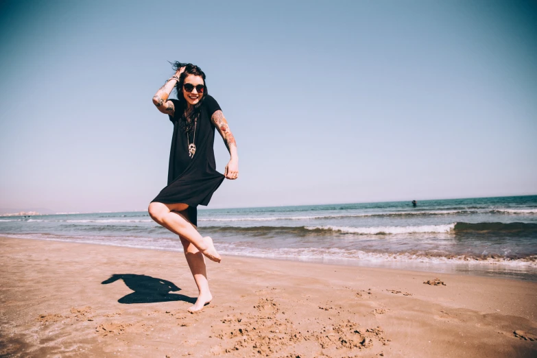 a woman is standing on the beach with one foot in the air