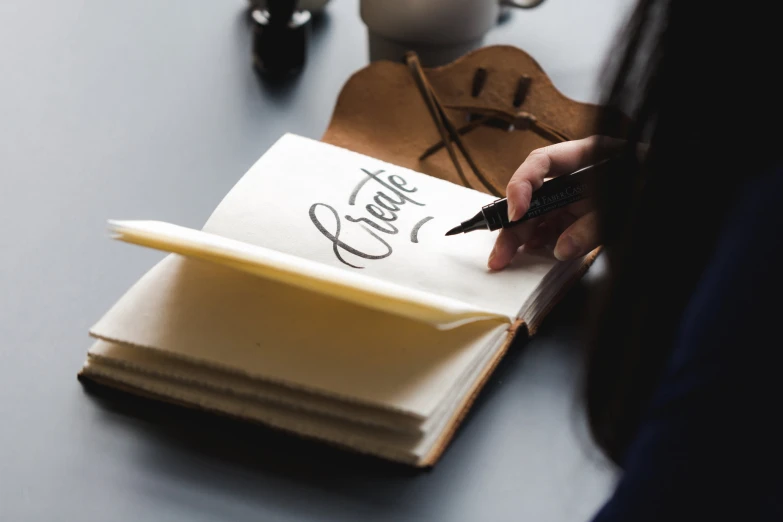 the lady is writing on an notepad with her pen