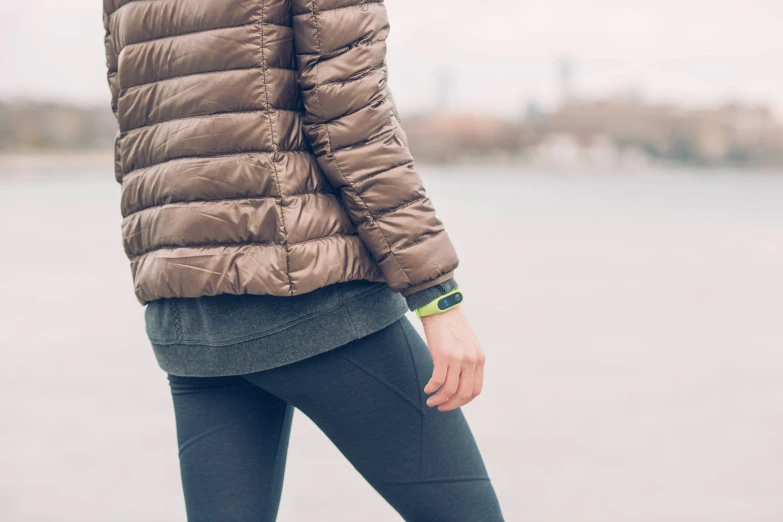 the back of a woman's jacket and pants, she wears all grey