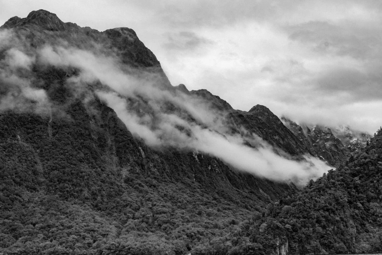 a mountain with some mist rolling up from the top