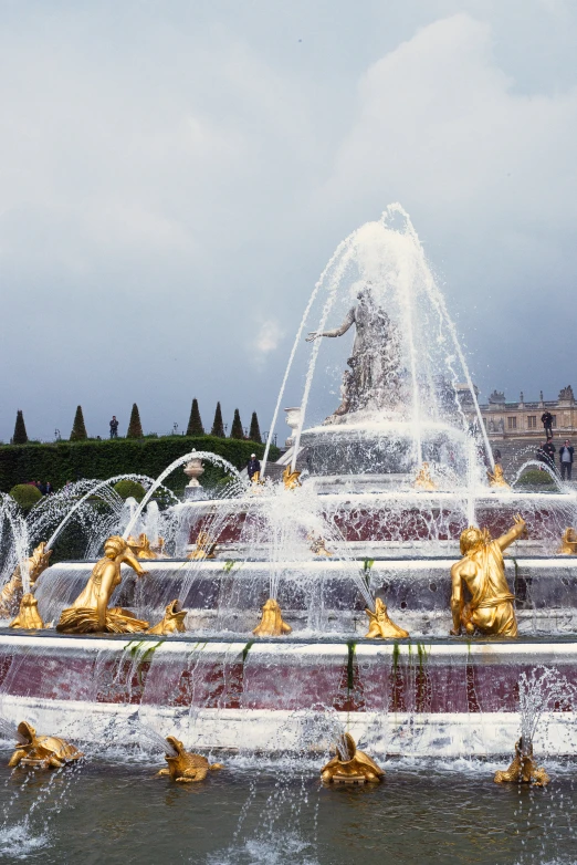 the gold sculptures are in the middle of this pond