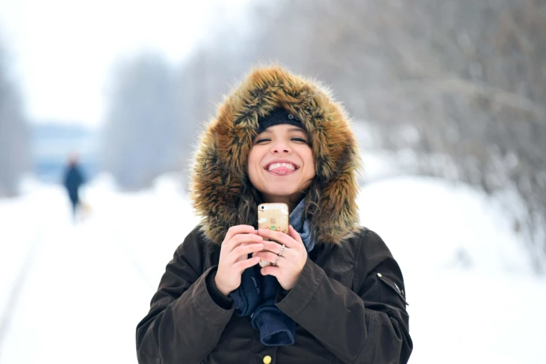 a  in winter clothing is using her cellphone