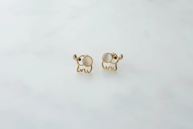 gold earrings with enamel and diamond details on the ear