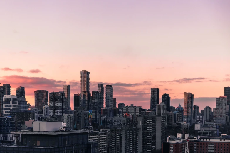 a cityscape, with several buildings, one at sunset