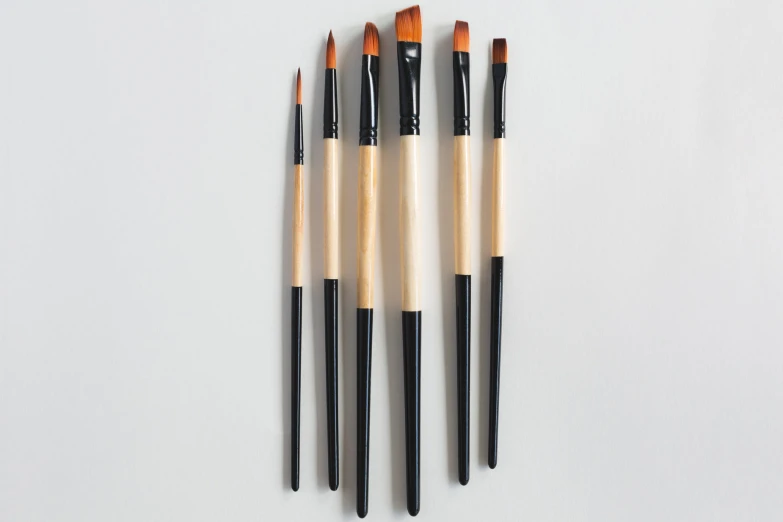 five wooden brushes lined up in the middle