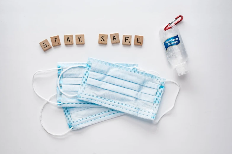 a group of medical masks sitting next to blocks that spell the word smile