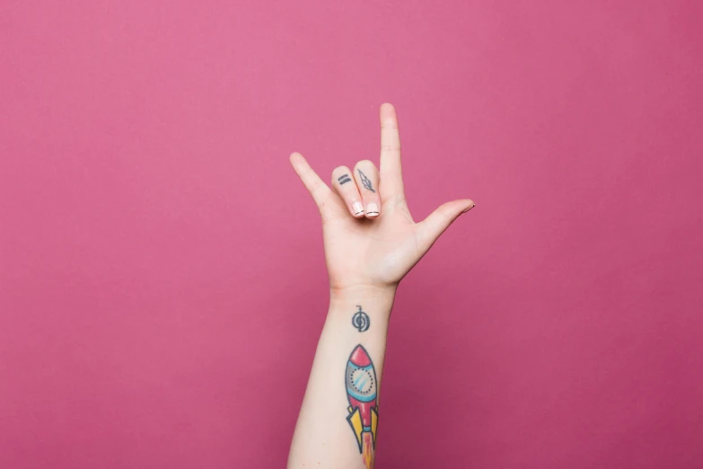 a hand with tattoos is gesturing towards soing