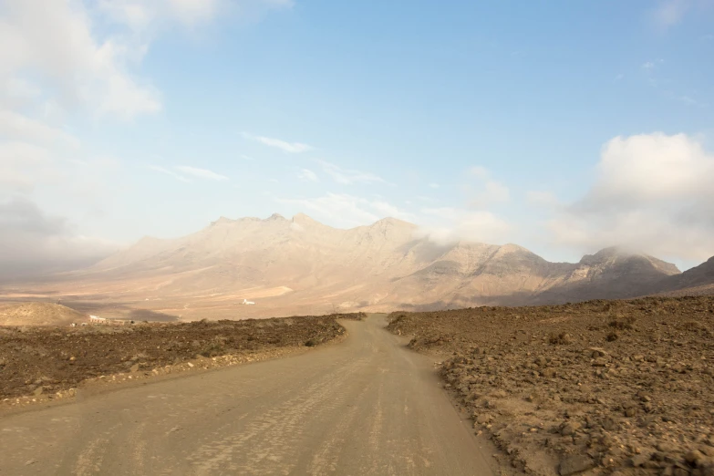 the motorcycle is traveling down the dirt road