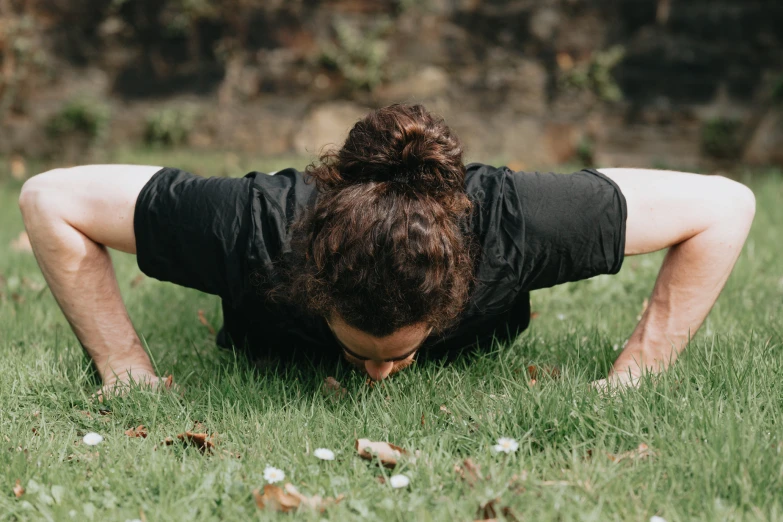 a man sitting on the grass doing yoga