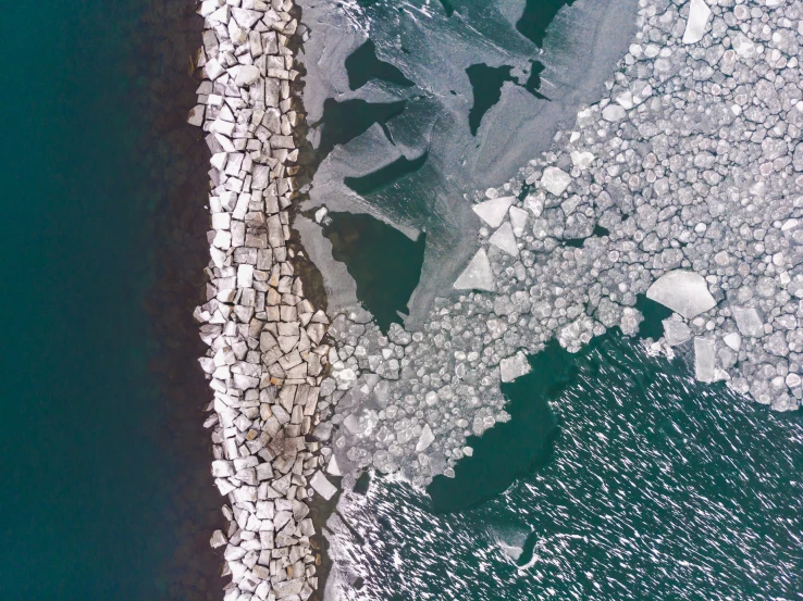 an aerial po of ice in the water with some rocks