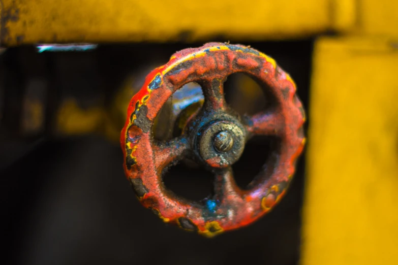 a yellow metal object with a rusted metal handle