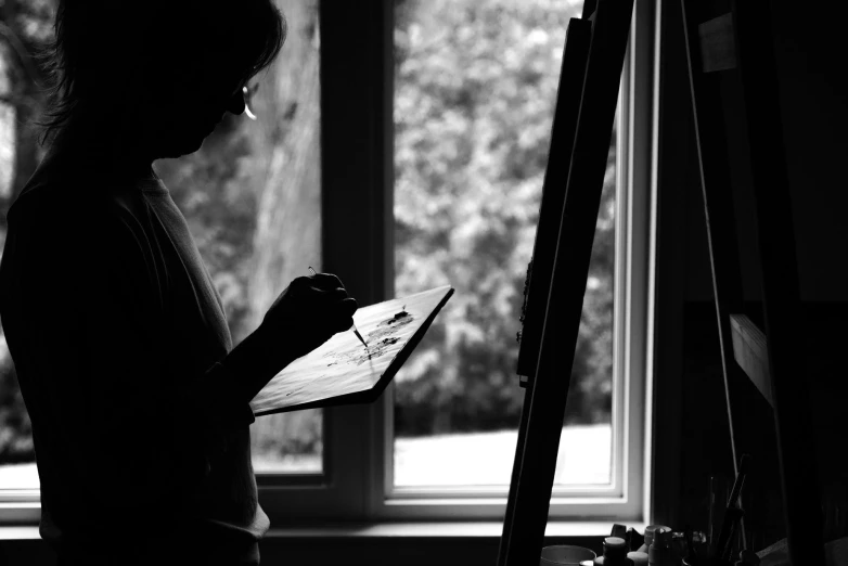 a woman that is standing up near a easel