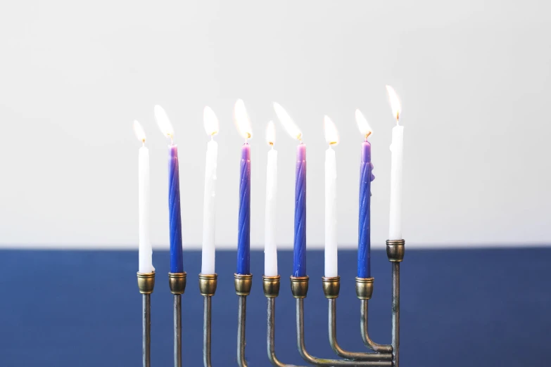 five lit candles are placed on a metal stand