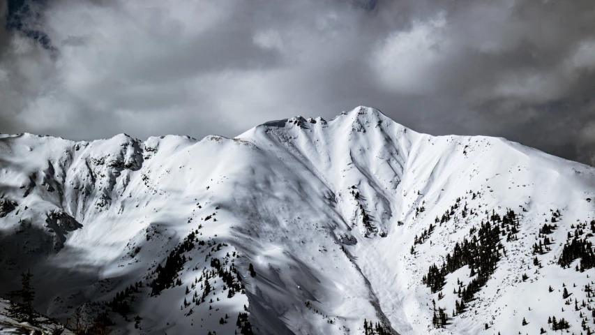 snowy mountains under an overcast sky during the day