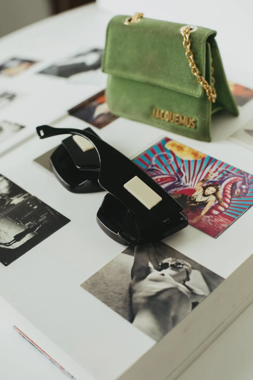 a book, purse, and sunglasses are on a table