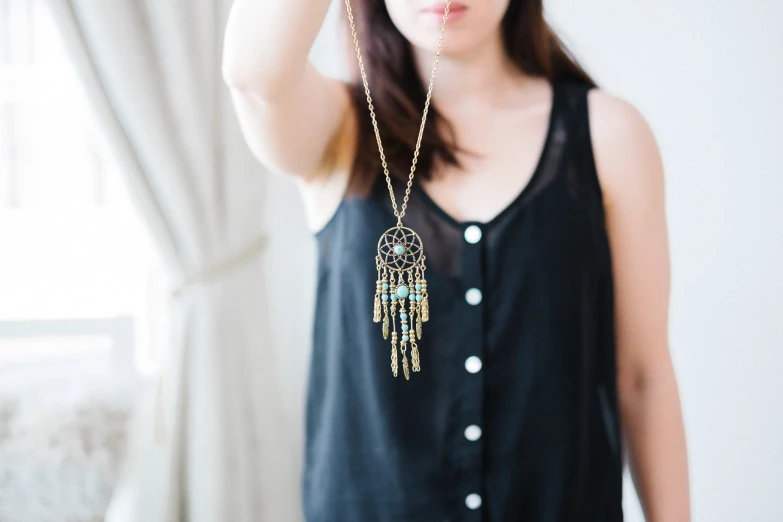 young woman wearing a black shirt and gold fringe necklace