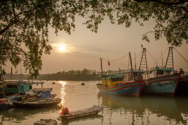 the sunsets over several boats on the water