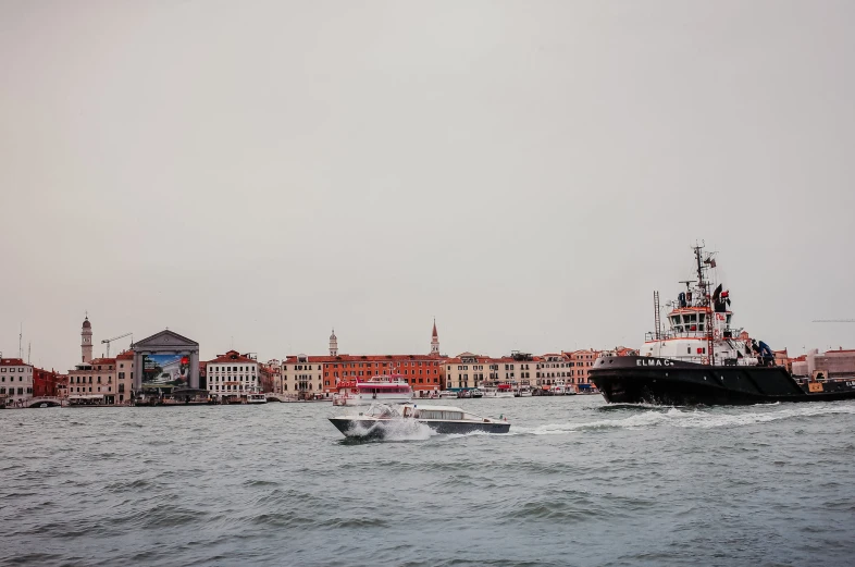 a large boat driving down the ocean in front of a city