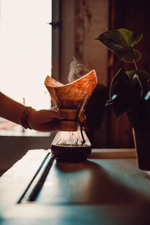 the person is pouring coffee into a cup on the table