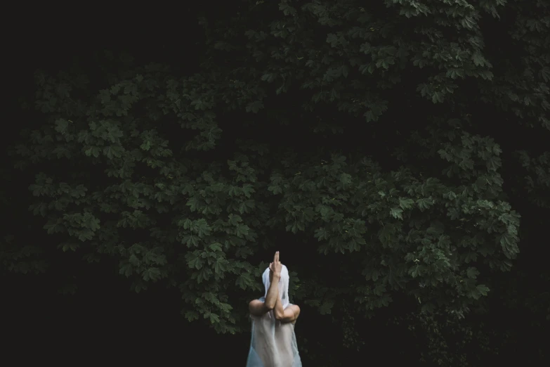 the woman is standing in the grass with her arms up