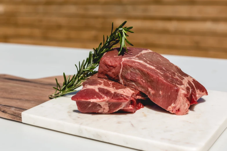 a couple of meat on top of a white  board