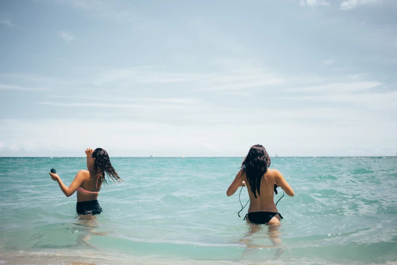 two women swim in the ocean together