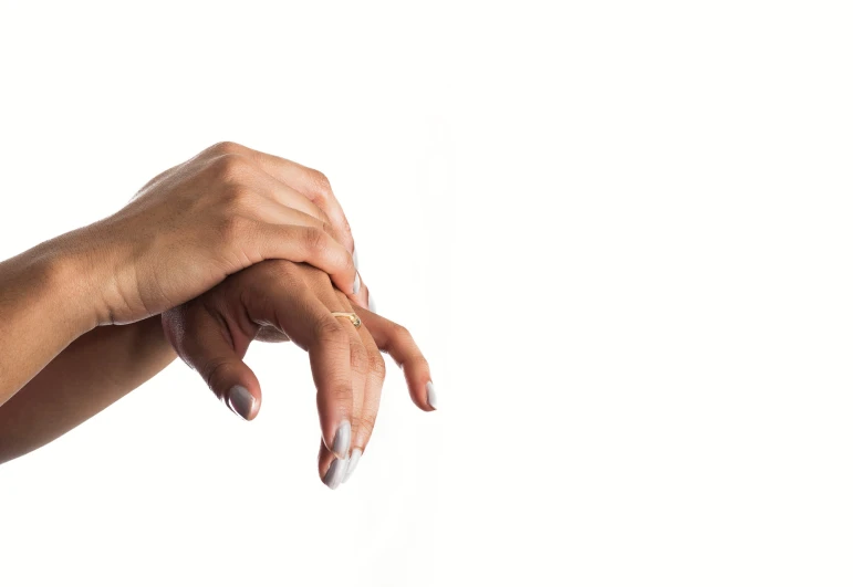 an image of a female hand with white nail polish