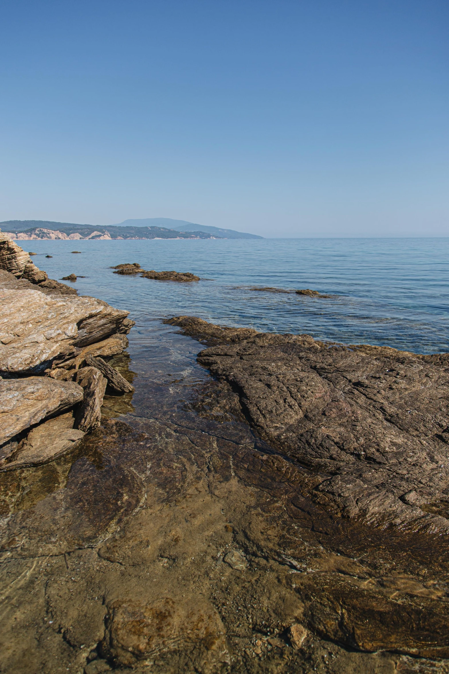 the ocean is calm and peaceful by the rocky shore