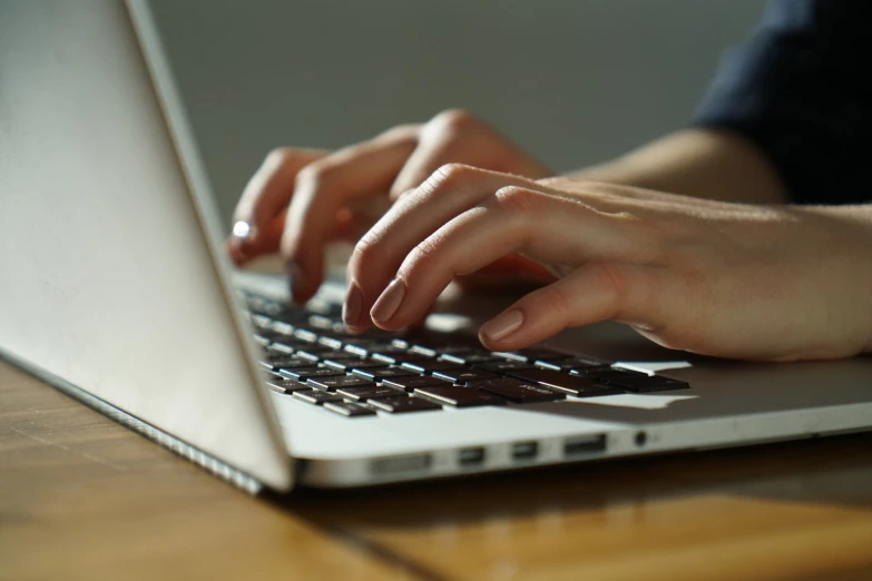 a close up of someone typing on a laptop keyboard