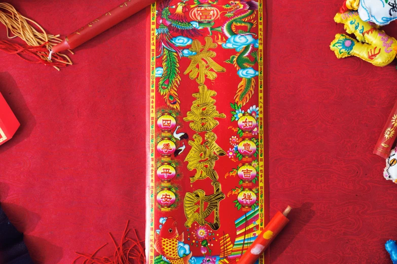 chinese decorations including a red ribbon, yellow pencils and chinese writing