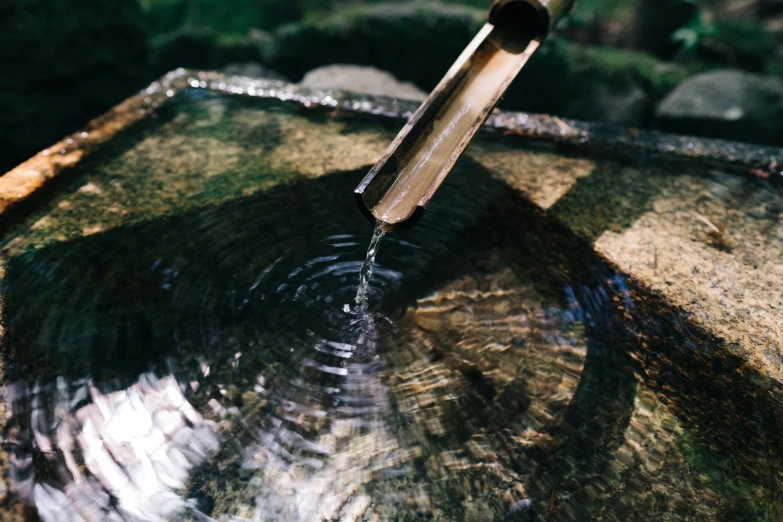 a small round wooden bowl with a stick sticking out