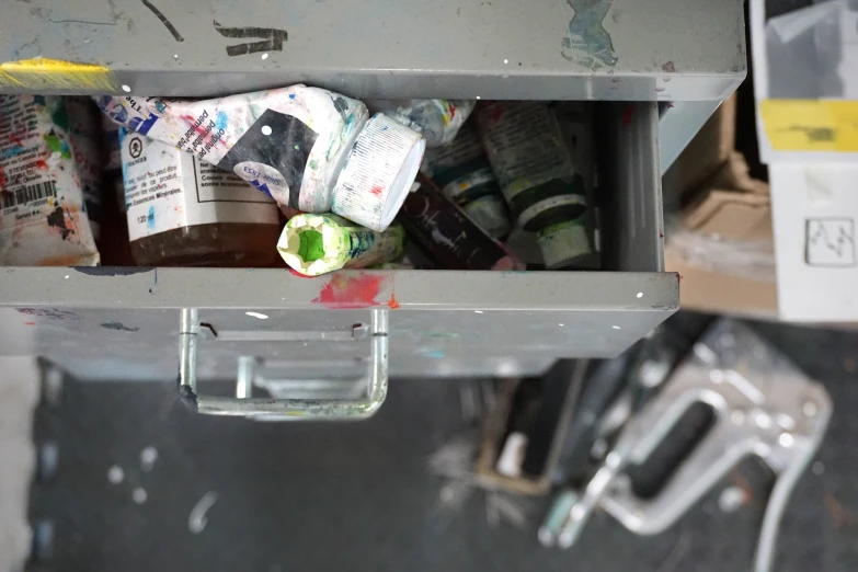 various bottles sit in a metal box under a roof