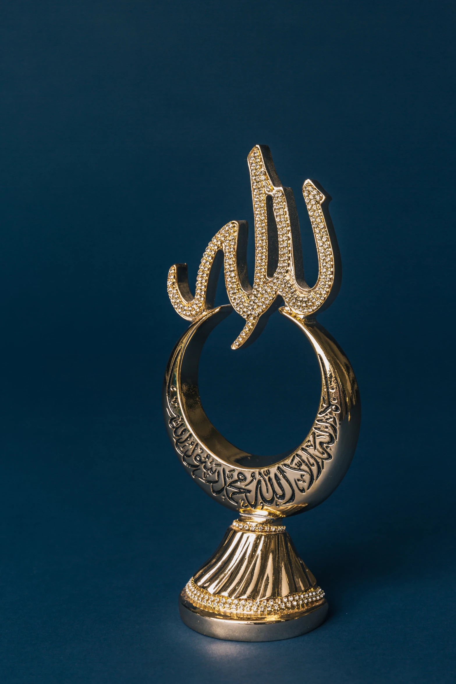 a gold decorated sculpture with arabic writing on it