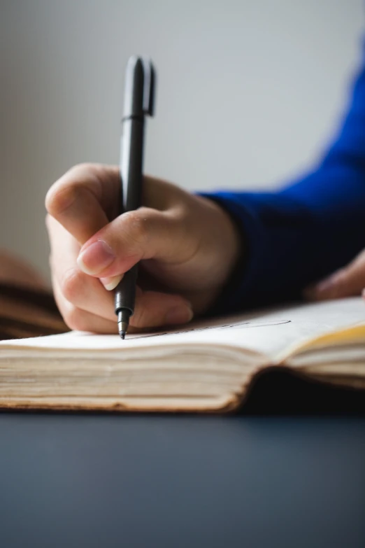 someone holding a pen taking notes in a notebook