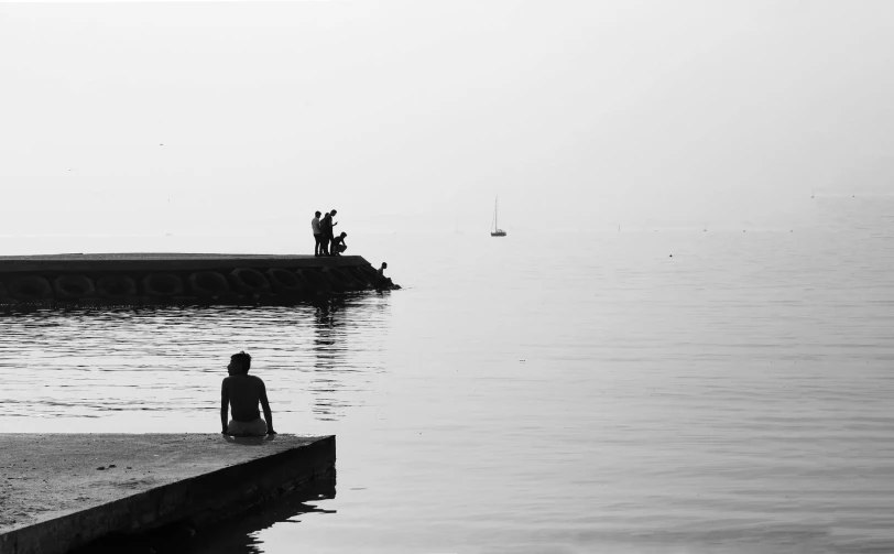 people on pier near ocean in large body of water