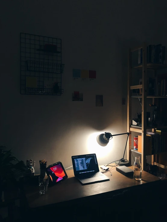 a computer and a laptop on a desk at night