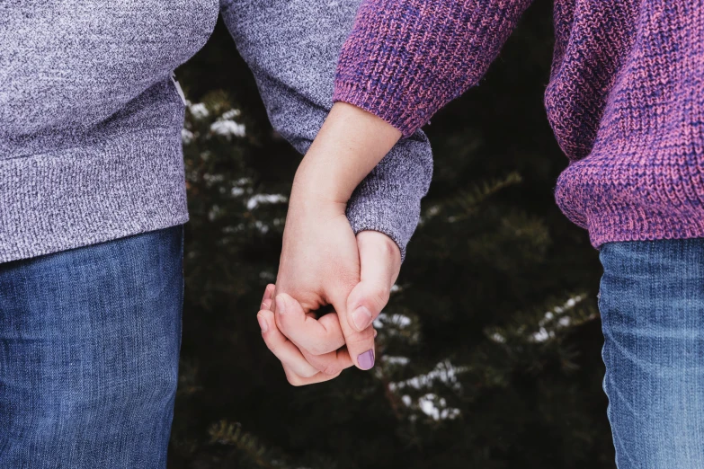 two people hold hands and walk away from the camera