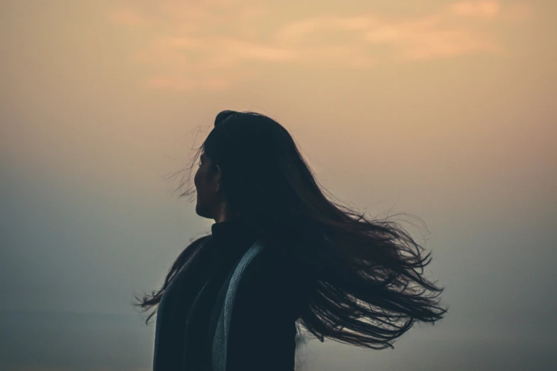 this woman has long hair flying in the sky