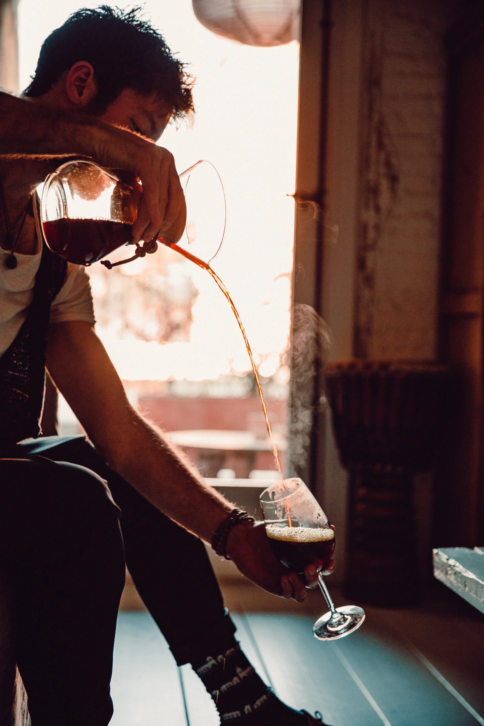 a man pours a glass of wine for his friend