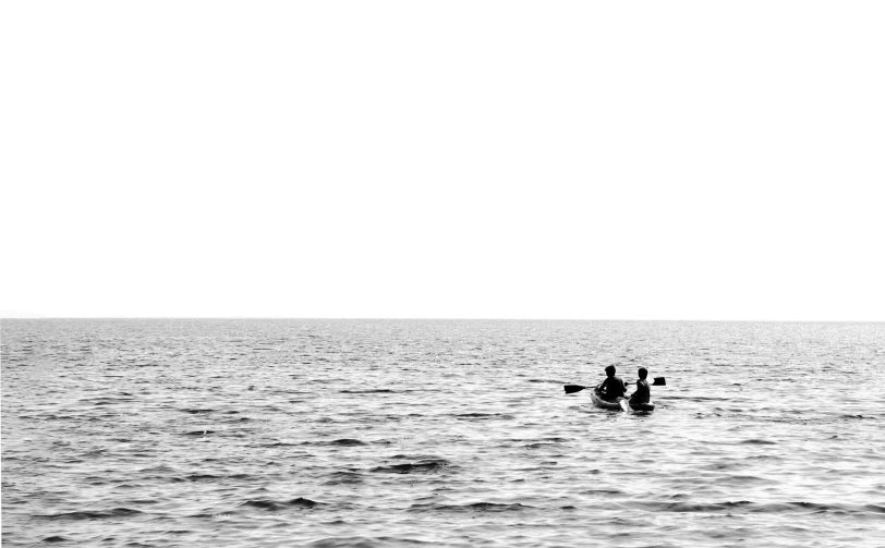 two people on surfboards paddle through the ocean