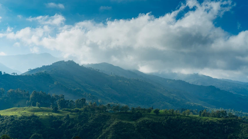 a mountain with rolling green hills and trees