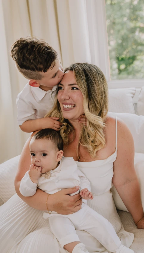 a mother and son smile while sitting in bed together