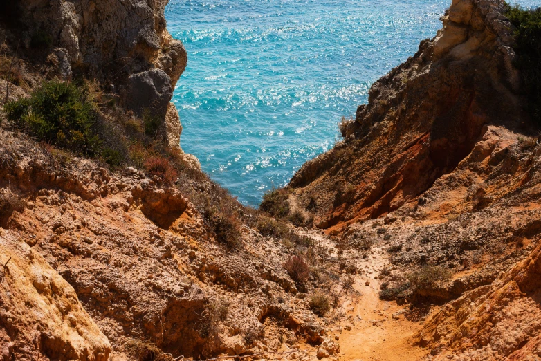 a cliff face is next to the water