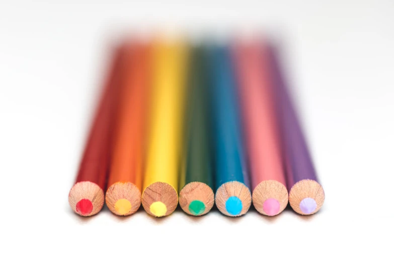 six rainbow colored pencils lined up against a white background