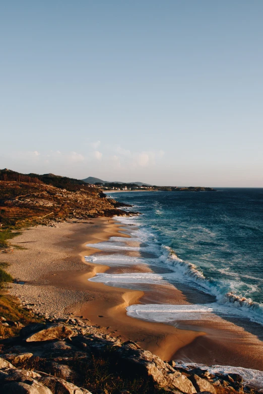 the ocean shore is rocky and empty with many waves