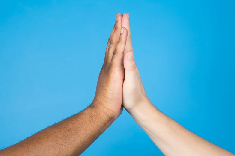 two people giving high five with one holding the other hand
