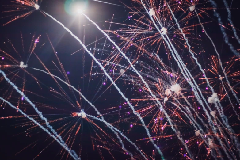 fireworks explode into the air in front of dark skies