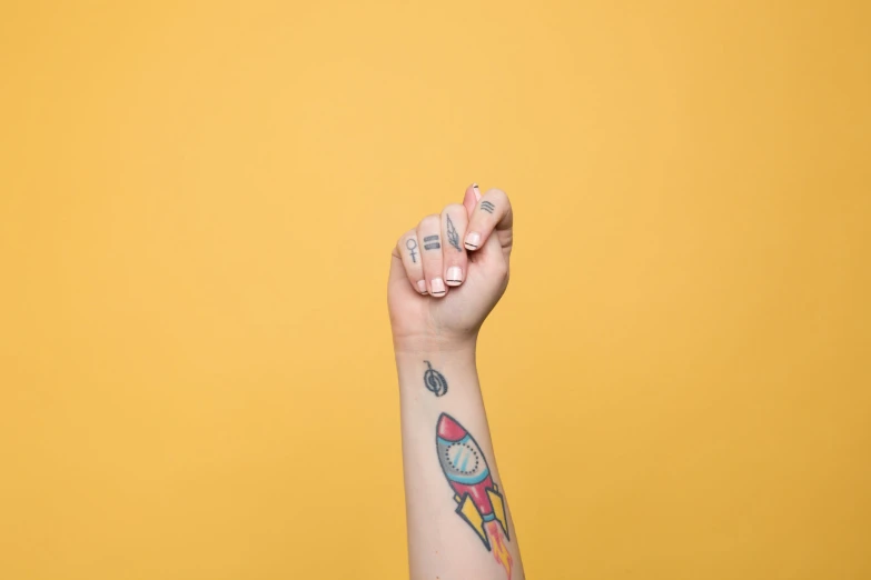 a hand that is in the air with an arm tattoo